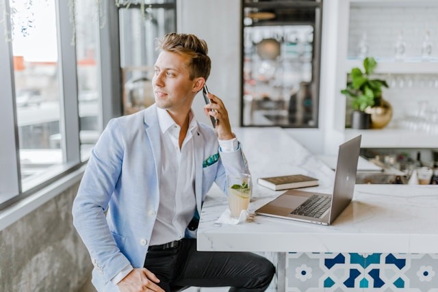 man-sitting-beside-white-wooden-table