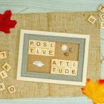 a picture frame surrounded by scrabbles and autumn leaves