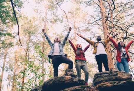 Four friends celebrating on rocky terrain outdoors